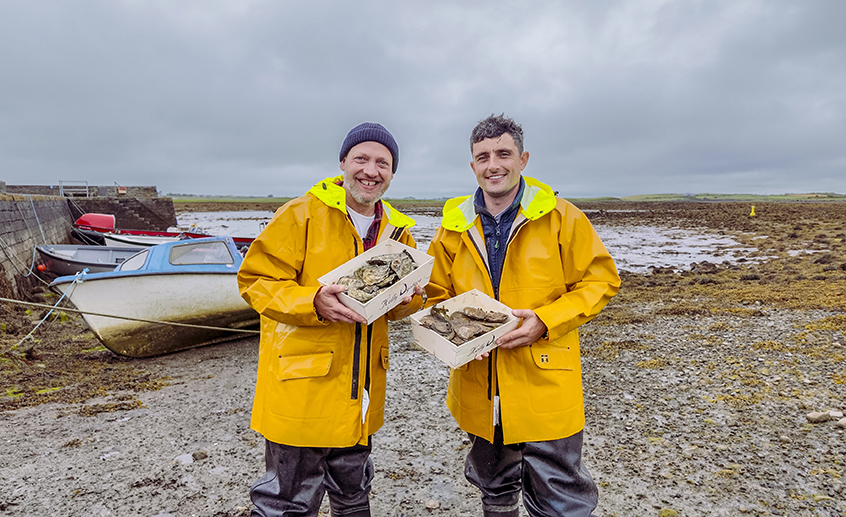 Two men in bright yellow rain jackets standing on a