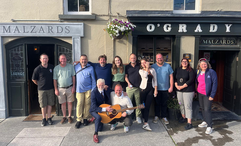 German travel agents pictured with a guitar outside O'Grady's pub