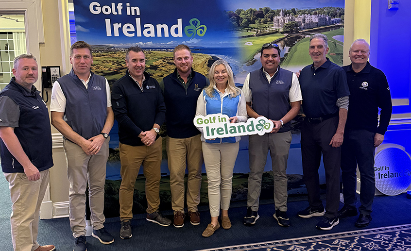 Copilot said: Group posing in front of a Golf in Ireland promotional display at a golf tourism event.