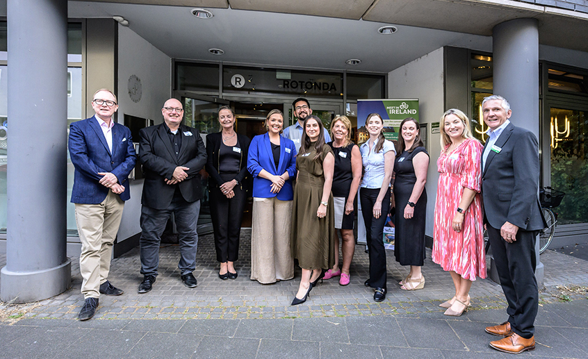 Group of people standing outside a venue entrance at a business event with a “Meet in Ireland” sign.