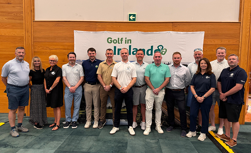 Group of tourism and golf industry representatives standing in front of a “Golf in Ireland” banner at an indoor event.