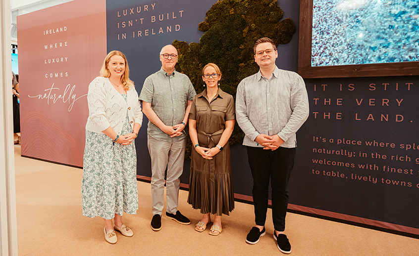 Four people standing in front of an event stand that says 'Ireland: where luxury comes naturally'.