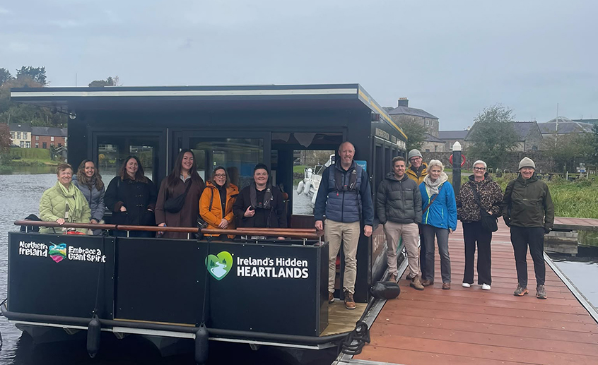 Group of tourism professionals standing on a canal boat and dock in Ireland’s Hidden Heartlands during a familiarisation visit.