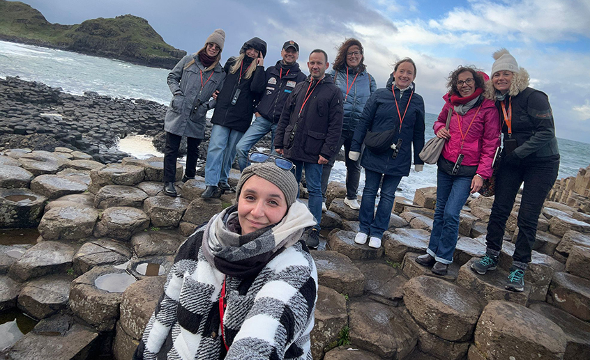 Group shot of ten people on the Giant's Causeway with the ocean in the background.