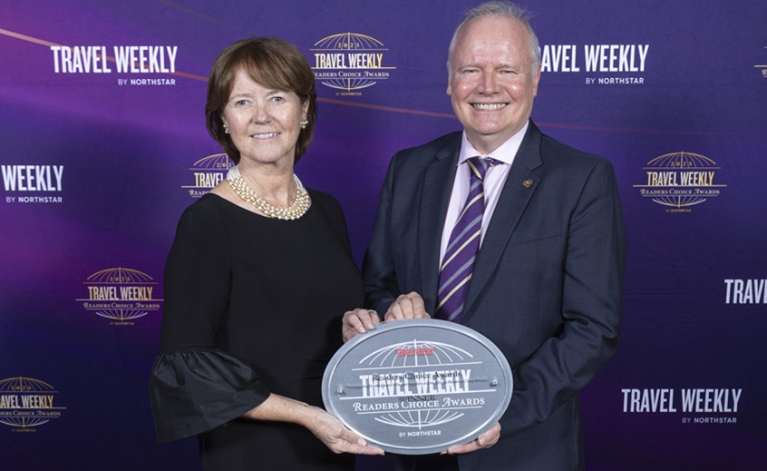 Two people holding an award that says 'Travel Weekly Readers Choice Awards'