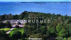 Stately home in wood in front of seascape
