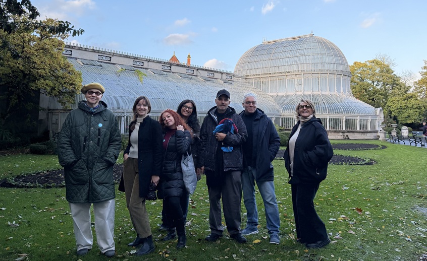 Italian journalists visiting Belfast’s Botanic Gardens, standing in front of the Palm House conservatory.