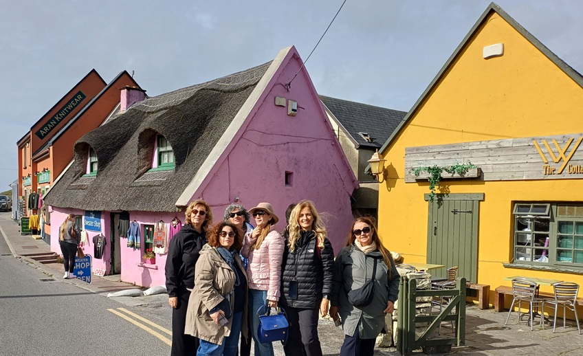 5 people in front of yellow and pink pubs.