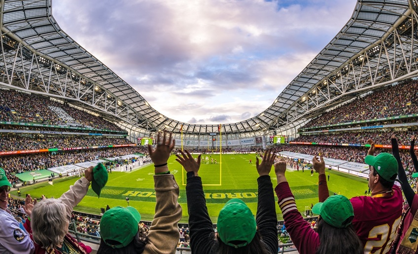 The crowd cheering with their hands in the air at the 2024 Aer Lingus College Football game at the Aviva Stadium, Dublin.
