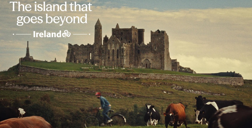 Castle on mountain with text 'the island that goes beyond' overlayed