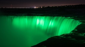 Dramatic waterfall illuminated in green.
