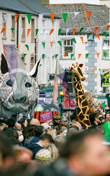 Festival in cityscape with green white and orange bunting.