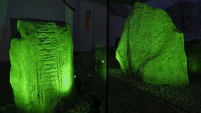 Two ancient stones illuminated in green light.