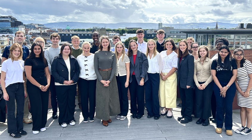 Group of people pictured on an office balcony with Dublin cityscape behind them.