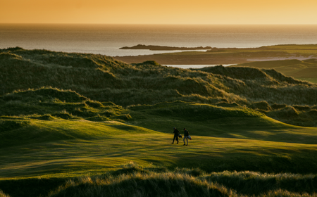DESKTOP LEAD_Carne Links Zwei Golfer auf dem Carne Links Golfplatz vor der dramatischen Kulisse der Halbinsel Belmullet