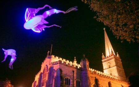 Eine beleuchtete Kirche und Feierfloaten beim Derry Halloween