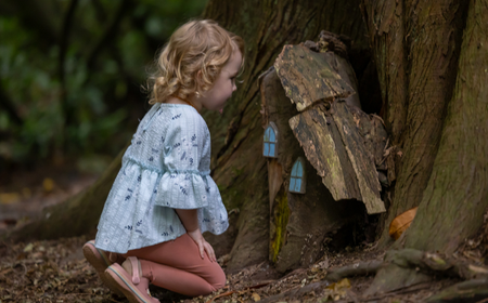 Ein Kind betrachtet ein kleines Holzhäuschen in den Belvedere House Gardens und im Park in Mullingar