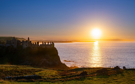 Sonnenuntergang über Dunluce Castle, gelegen an der Causeway Coastal Route