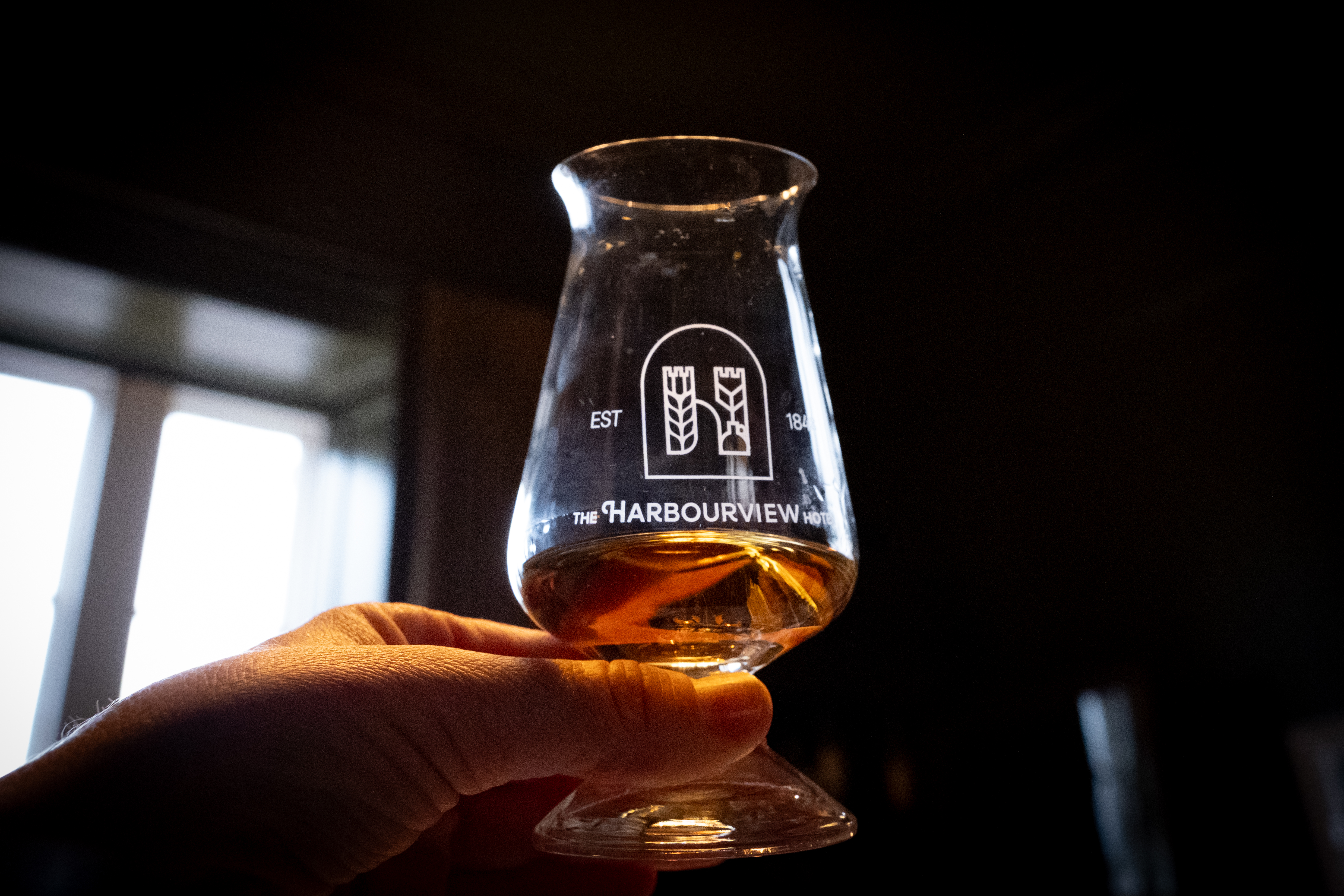Whiskey Tasting Harbourview Hotel Carnlough Co Antrim.jpg_TI72Y6I Jemand, der im Harbourview Hotel ein Glas Whisky in der Hand hält